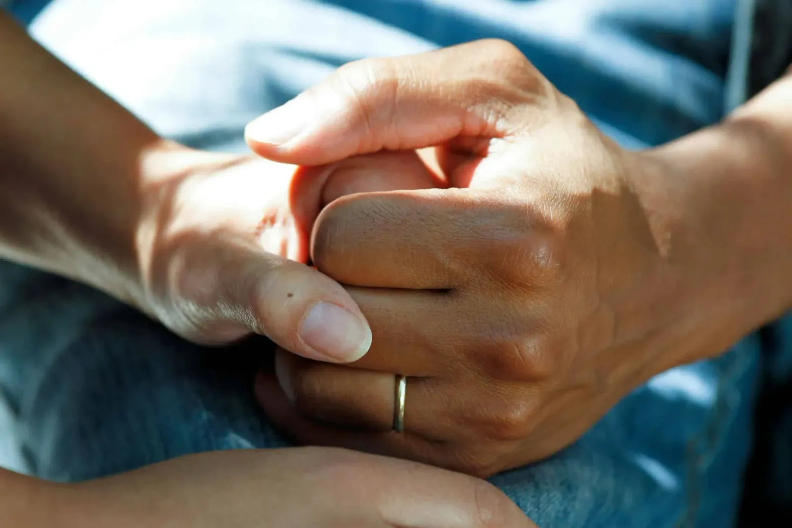 Close-up of one person holding another's hands in reassurance, representing senior care in the Sensorscall customer story.