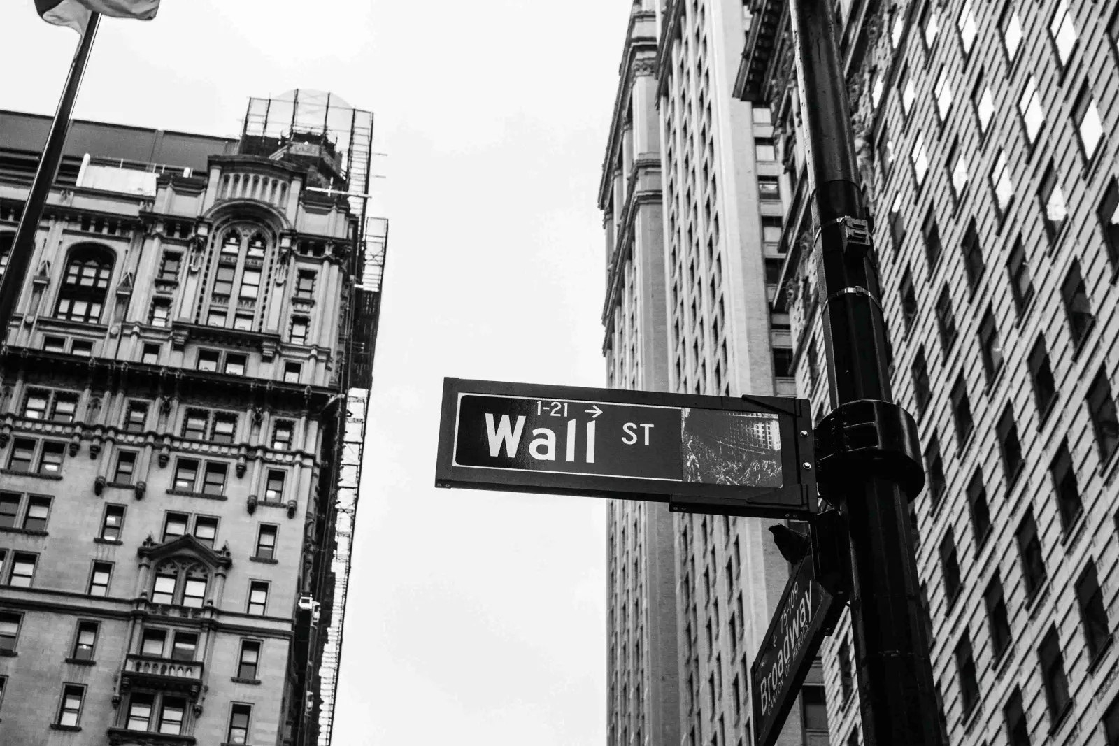 Black and white photo of a Wall Street sign between tall buildings, used for the Consero Global financial review story.